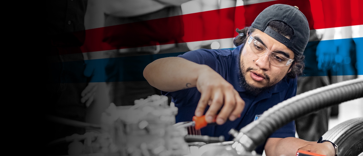 Automotive student working on engine components in a hands-on training lab.