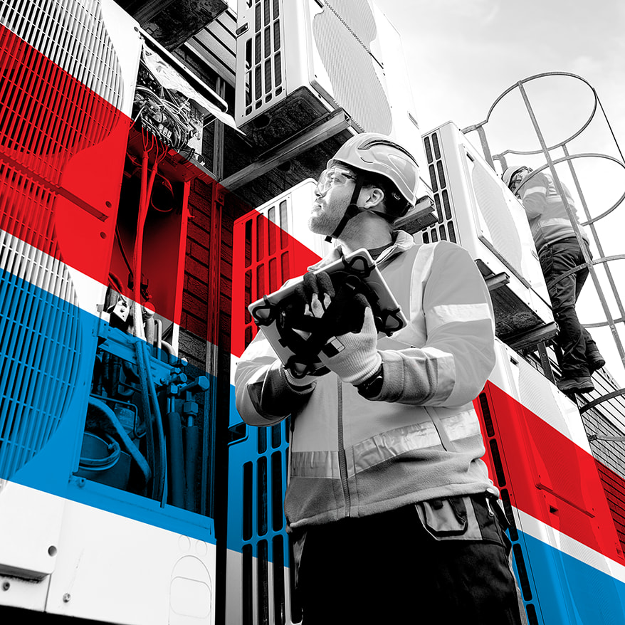 UTI trade school graduate wearing a black cap and gown with honor cords, smiling at commencement ceremony.